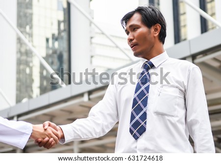 Business man are shaking hand on cityscape background