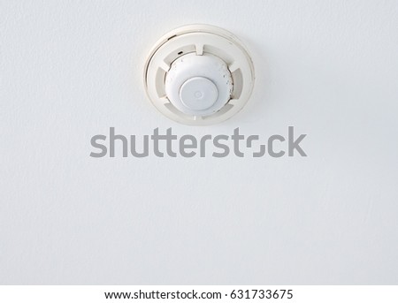 Smoke detector with copy space on the ceiling of the office building.