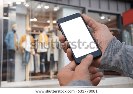 Man hand using blank isolated screen mobile smart phone with blurred background fashion shop in shopping mall in the city, internet banking concept