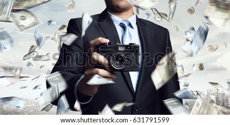 Businessman taking photo with vintage camera