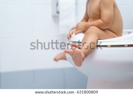 A year and 3 months old Asian baby sit on a kid bathroom accessory toilet Royalty-Free Stock Photo #631800809