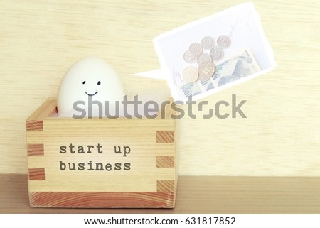 starup business incubator box and the egg to represent the startup company with profitable business plan (with japanese money and graph)
