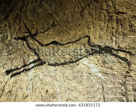 Caveman symbols on sandstone wall. Paint of human hunting,  prehistoric picture.. Black carbon paint of deer on sandstone wall. Abstract art in sandstone cave.  Discovery of human history