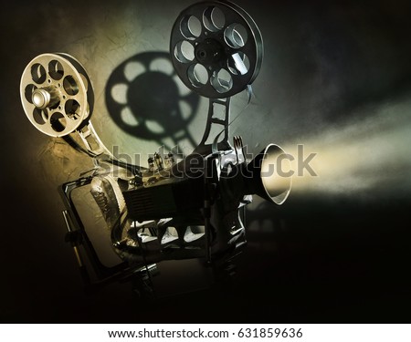 Old movie projector with the film on the dark background