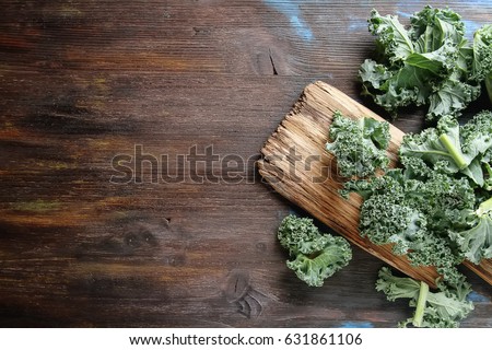 Fresh sliced Italian Kale salad on old wooden board. Dark background.