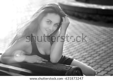 Beautiful young female model with dark curly hair and big bright eyes posing, walking, laughing at summer city park