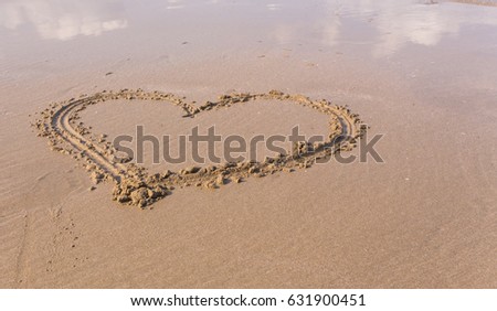 Heart in the sand on the beach at sunset.anniversary or honeymoon