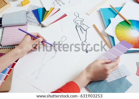 Clothes designer coloring new dress model in pale lilac