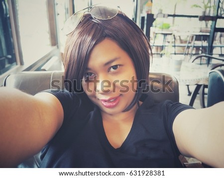 Woman taking a selfie in cafe