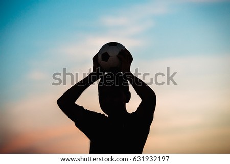 kids are playing soccer football for exercise under the sunlight. Silhouette and film picture style.