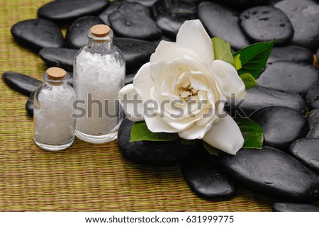 gardenia with salt in bottle and pile of stones on mat 