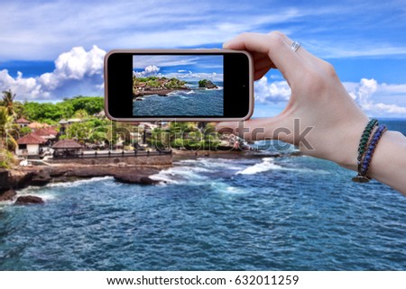 A woman photographs the beautiful sea landscape . Close-up of hands.