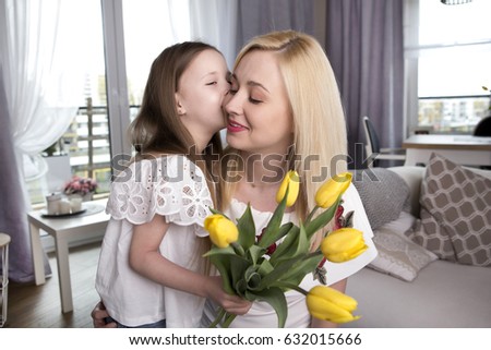  Happy mother's day. Child daughter gives moms flowers tulips. 