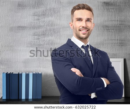Young man and books on background