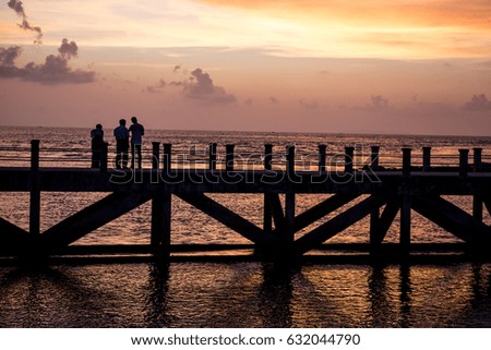 silhouette picture 3 man walking on the bridge when sunset time