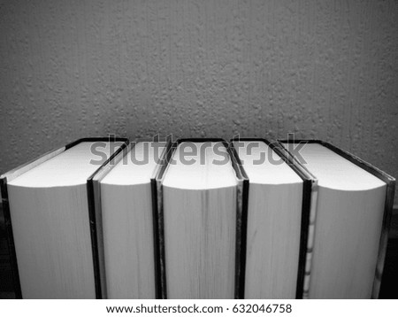 Black and white image of a row of books pages facing outward