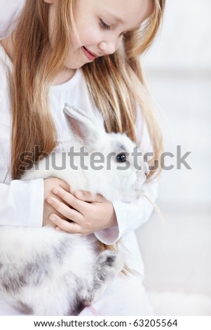 Beautiful little girl holding a funny bunny