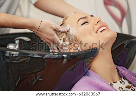 Young beautiful blonde woman enjoying hair treatment.
