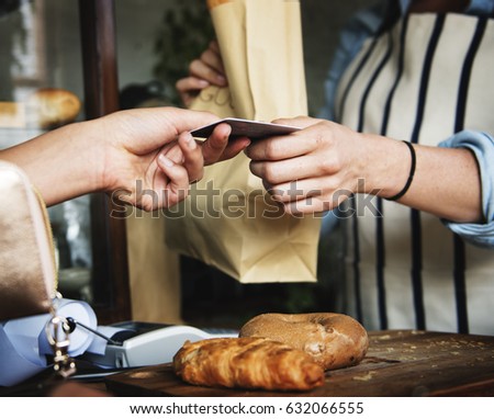 Buyer and seller at pastry shop paying by credit card