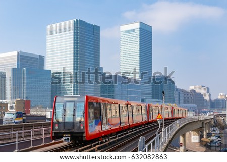 Docklands light railway in London with Canary Wharf in the background Royalty-Free Stock Photo #632082863