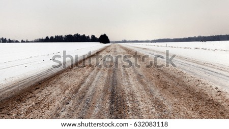  picture taken in winter after snowfall on a small rural road. Snow on the ground