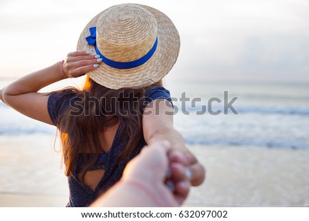 Beautiful girl in a hat holds a hand of a guy