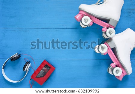 Sport, healthy lifestyle, roller skating background. White roller skates, headphfones and vintage tape player. Flat lay, top view.