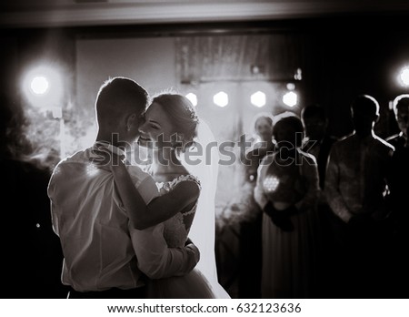 Black and white picture of gorgeous wedding couple dancing in the restaurant