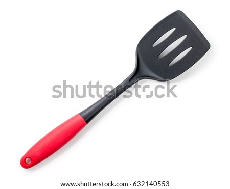 Black plastic kitchen spatula with red handle isolated on a white background. Top view, close up. Royalty-Free Stock Photo #632140553