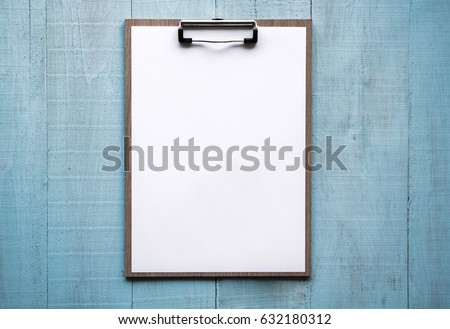 Clipboard with white paper on wood background. Top view. Mock up for word. Royalty-Free Stock Photo #632180312