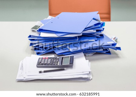 file folder and Stack of business report paper file and calculator, pen, pencil, on table in meeting room 
