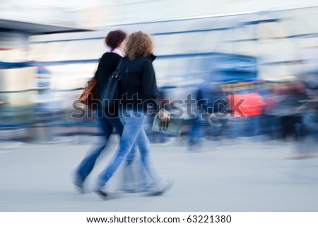 Blurred image of two woman rushing to work in the morning