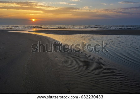 River delta on the beach at the sea coast in summer sunset