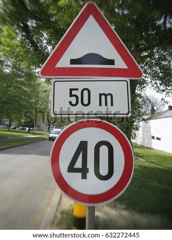  Traffic signs, danger sign, 50 m, uneven road, allowed speed 40, blurred image.                              