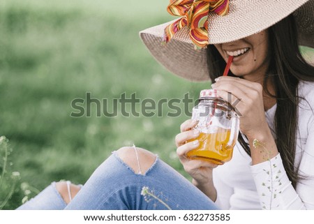 Relaxing woman and drinking cold orange juice. Looks like film photo