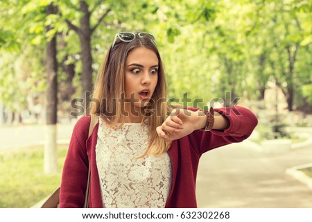 Woman being late to a rendez-vous. Closeup portrait headshot view stressed young attractive beautiful businesswoman checking the time outdoor isolated park cityscape outdoor background. Mixt race girl Royalty-Free Stock Photo #632302268