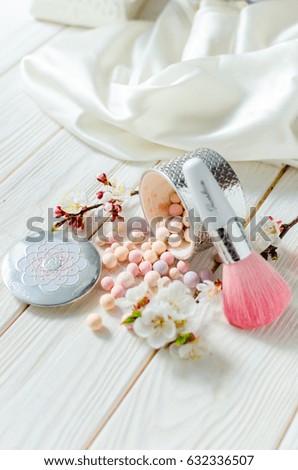 Glamorous spring still life. Powder for the face in balls on a light wooden table