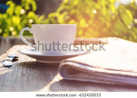 coffee cup clock and news paper on old wooden table nature background the good morning