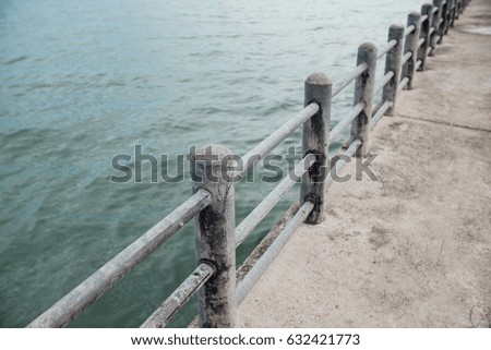 Handrail on the pier on the background of the sea. Thailand asia. Concrete road.