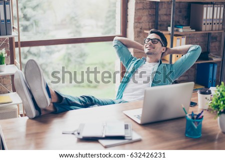 Happy calm smiling man having a rest after solving all the tasks at work Royalty-Free Stock Photo #632426231