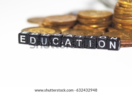 Plastic block with a Education words on stacked coins - Business Concept