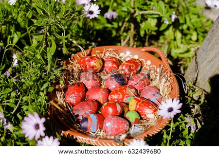 Colorful Easter eggs on ceramic plate green grass background. Seasonal traditional handmade religious decoration