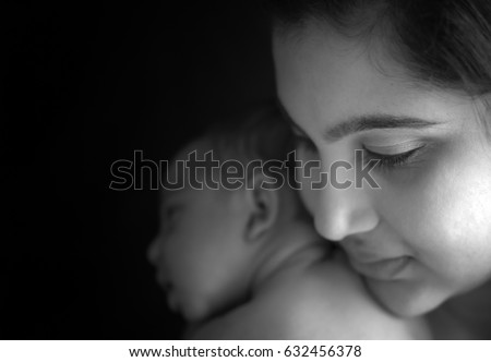 Model released photograph of a mother looking at her baby