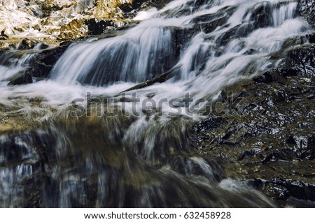 beautiful nature,cascaded tropical river flowing through over wet rock at sunny day