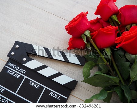 Clapperboard and roses on a wooden background, space for text, concept photography, awards, film, movie