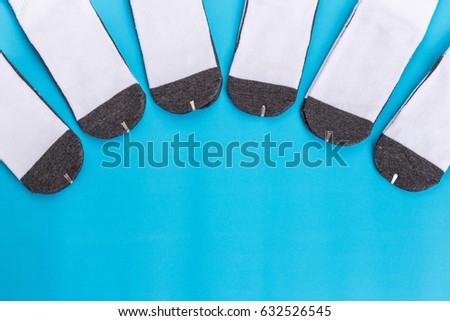 Top view new white student sock on blue background with free space for design.