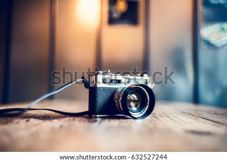 Monday morning at cafe.Vintage film camera on wood table in abstract background. Vintage tone.