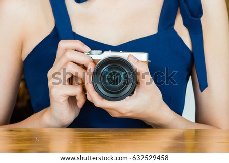 Woman holding camera with both hand