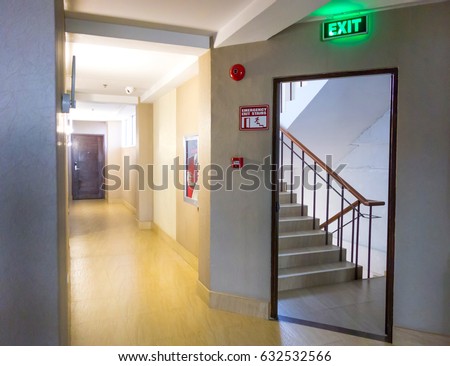 Building Emergency Exit with Exit Sign and Fire Extinguisher. stairwell fire escape in a modern building.