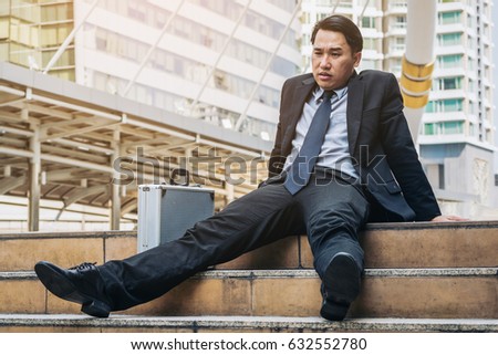 Desperate businessman sitting hopelessly on stair floor. Concept of failure, desperation, unemployment, business depression.